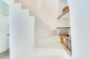 una escalera con escaleras blancas y libros en Ses Salines Terrace Home en Ses Salines