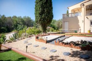 a garden in front of a house with rocks at Villa Rhéa in Roquebrune-sur-Argens