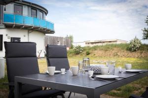 un tavolo nero con due sedie e un tavolo con bicchieri di Wasserturm a Pruchten