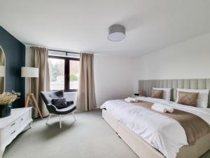 - une chambre avec un grand lit et une chaise dans l'établissement Sporthaus Sosnówka - Villa Deluxe, à Sosnówka