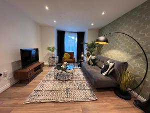 a living room with a couch and a tv at Modern 2 Bedroom Aesthetic Apt in Manchester