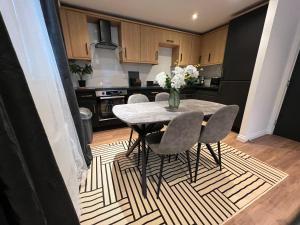 a kitchen with a table with chairs and a vase of flowers at Modern 2 Bedroom Aesthetic Apt in Manchester