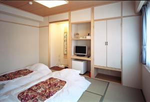 เตียงในห้องที่ Kochi Ryoma Hotel