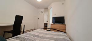 a bedroom with a bed and a chair and a television at Luton, LU3 Double Ensuite room in Luton