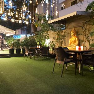 a restaurant with tables and a statue of a buddha at Quality Inn Mint in Pune
