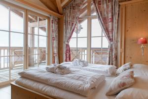 two beds in a room with windows at AvenidA Panorama Chalet by Alpin Rentals in Piesendorf