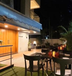 an outdoor patio with tables and chairs at night at Quality Inn Mint in Pune