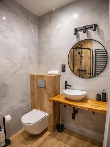 Un baño con un inodoro blanco y un lavabo. en Stylove Apartamenty, en Ustrzyki Dolne