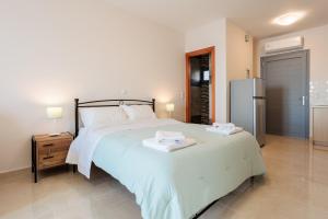 sypialnia z dużym łóżkiem i lodówką w obiekcie Georgia seaview apartment B3 w Kalamácie