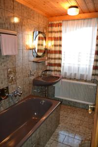 een badkamer met een bad en een wastafel bij Landhaus Buchsteiner in Forstau