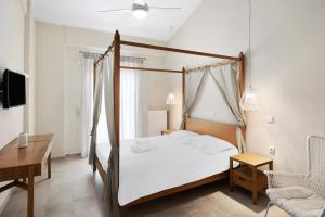 a bedroom with a canopy bed with a desk and a chair at Aria Monte Villas in Raches