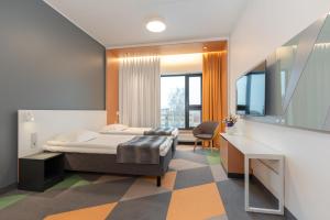 a bedroom with a bed and a desk and a chair at Hotel Sophia by Tartuhotels in Tartu