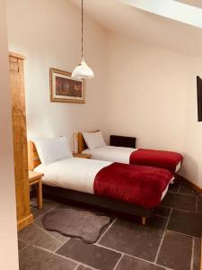 1 dormitorio con 2 camas y banco rojo en Detached Barn in Tamar Valley, EV charging included, en Yelverton