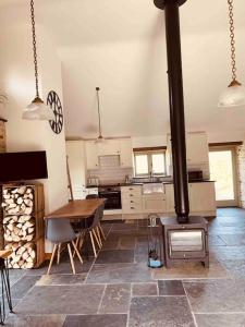 a kitchen with a wood stove and a table at Detached Barn in Tamar Valley, EV charging included in Yelverton