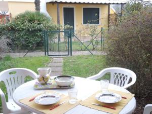 una mesa blanca con platos y tazones. en Amazing apartment with terrace for 5 guests, en Bibione