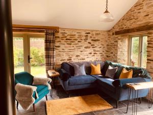 a living room with a blue couch and chairs at Detached Barn in Tamar Valley, EV charging included in Yelverton