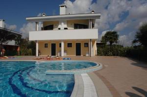 una casa con piscina frente a una casa en Amazing apartment with terrace for 5 guests, en Bibione
