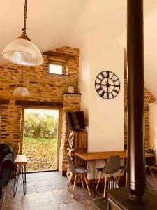 a living room with a clock on the wall at Detached Barn in Tamar Valley, EV charging included in Yelverton