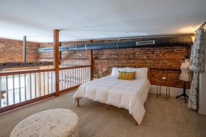 a bedroom with a bed and a brick wall at Ultra Chic Loft sleeps 4 in Fayetteville