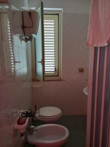 ein Badezimmer mit einem WC, einem Waschbecken und einem Spiegel in der Unterkunft Room in Apartment - 15min Da Tropea Monolocale Vista Mare A Briatico in Briatico