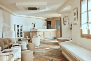 a living room with white furniture and a table at Naxos Magic Village in Stelida