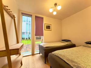 a bedroom with two beds and a window at Cityfjord apartment in Bergen centrum in Bergen