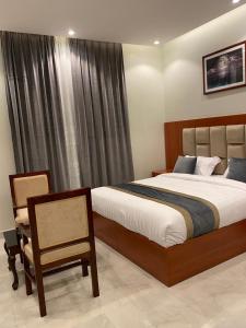1 dormitorio con 1 cama, 1 silla y 1 ventana en فندق الأفنيوز بالرس en Al Rass