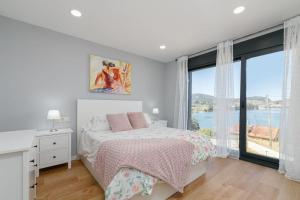 1 dormitorio con cama y ventana grande en Casa nueva con piscina y vistas al mar, en Vilaboa