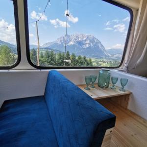 a bench in a room with a large window at Glampingbus Lindwurm in Irdning