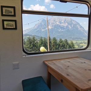 una ventana de tren con vistas a la montaña en Glampingbus Lindwurm, en Irdning