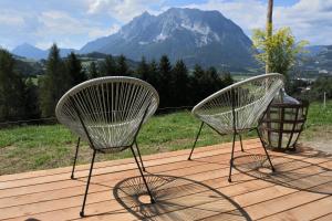 two chairs sitting on a deck with a mountain at Tiny House Feeling mit Weitblick in Irdning