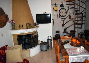 a living room with a fireplace and a table and a television at Ethia 2Floor Mountain View Cottage garden wifi ac in Ethiá