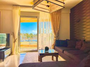 Marousi Luxury Apartment في أثينا: غرفة معيشة مع أريكة ونافذة كبيرة