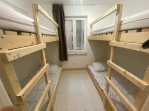 Cette chambre comprend 2 lits superposés et une fenêtre. dans l'établissement Oostduinkerke Apartments, à Oostduinkerke