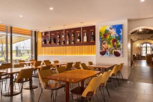 a restaurant with tables and chairs and a painting on the wall at Hotel Restaurant Sol i Vi in Lavern