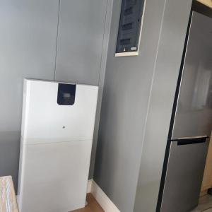 a white refrigerator in a kitchen next to a wall at Waves Edge CP3 in Cape Town