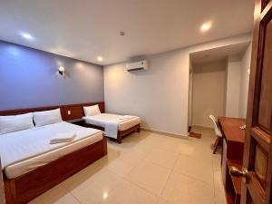 Habitación de hotel con 2 camas y escritorio en Bao Chieu Inn, en Hà Tiên
