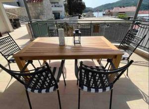 einen Holztisch und Stühle auf dem Balkon in der Unterkunft Apartments Fig&Olive in Zaton