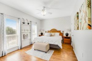 ein weißes Schlafzimmer mit einem Bett und einem Stuhl in der Unterkunft Bay Dreamin - Gulf Shores,Al in Gulf Shores + 52 Fotos