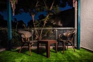 two chairs and a table on a patio at night at Ra Residence - Agarwal Group of Hotels in Pune