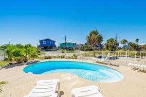 einen Pool mit Liegestühlen und einem Zaun in der Unterkunft Bay Dreamin - Gulf Shores,Al in Gulf Shores