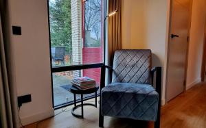 um quarto com uma cadeira, uma mesa e uma janela em Bosfluiter em Halle