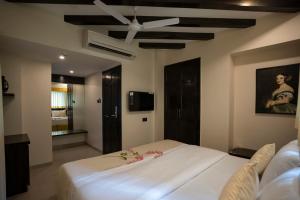 a bedroom with a white bed and a ceiling fan at Ra Residence - Agarwal Group of Hotels in Pune