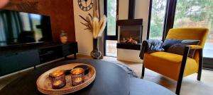 a living room with a table and a fireplace at Bosfluiter in Halle