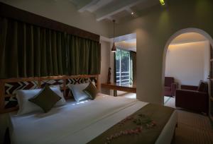 a bedroom with a large bed with a large window at Ra Residence - Agarwal Group of Hotels in Pune