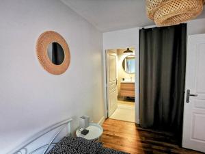 een slaapkamer met een bed en een spiegel aan de muur bij Chez Serge - Petit Matabiau - 2/4 pers - Pkg/Centre in Toulouse