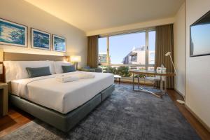 a hotel room with a large bed and a large window at Melia Lisboa Oriente Hotel in Lisbon