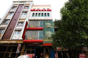 un edificio alto con ventanas coloridas en una calle de la ciudad en Hotel Aditya Palace By WB Inn, en Kānpur