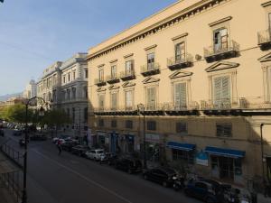 una calle con coches estacionados en el lateral de un edificio en B&B Liberty, en Palermo