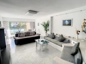 a living room with two couches and a table at Appartements de Standing Cannes Centre in Cannes